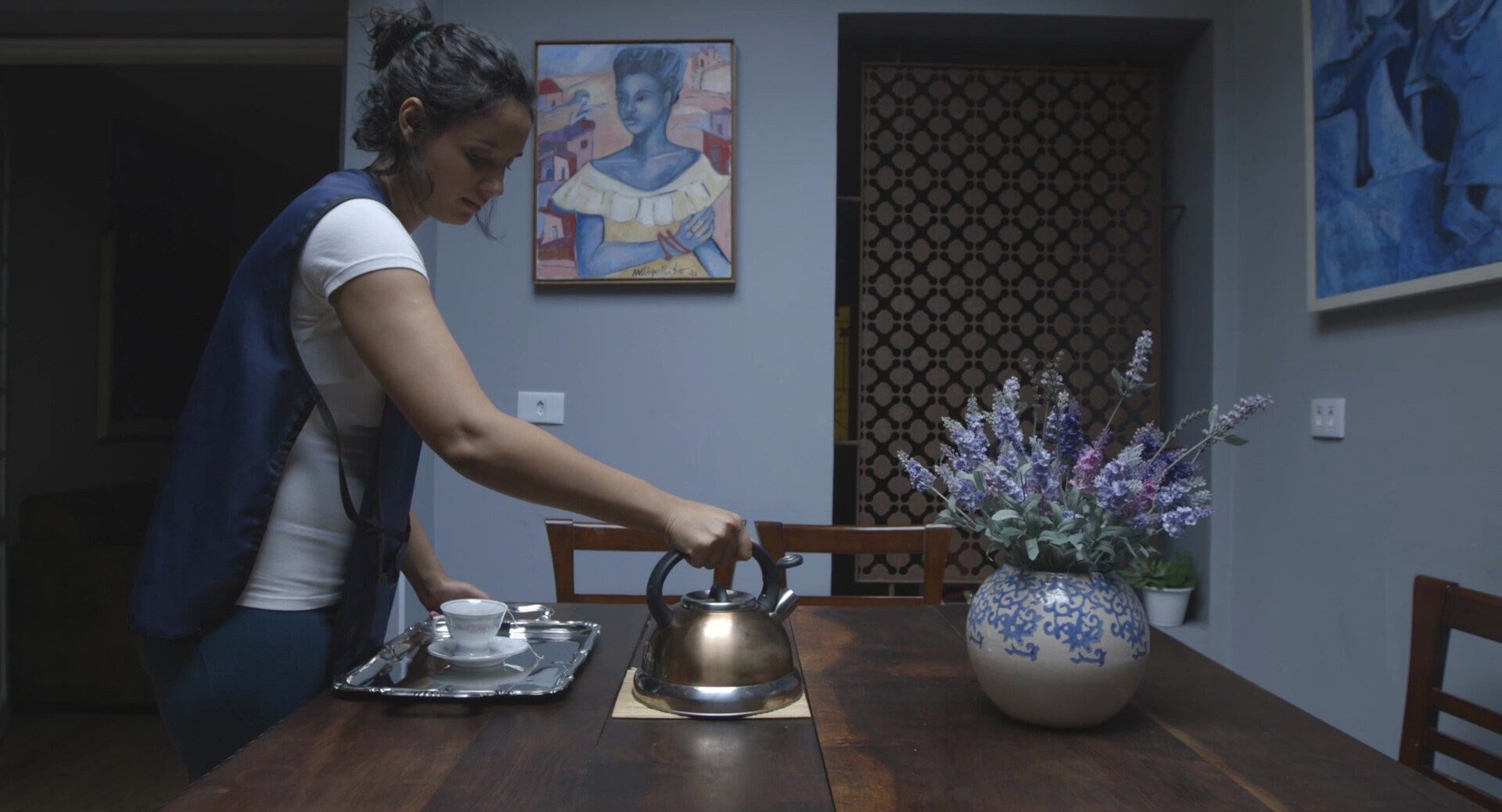 Mulher coloca uma chaleira sobre uma mesa